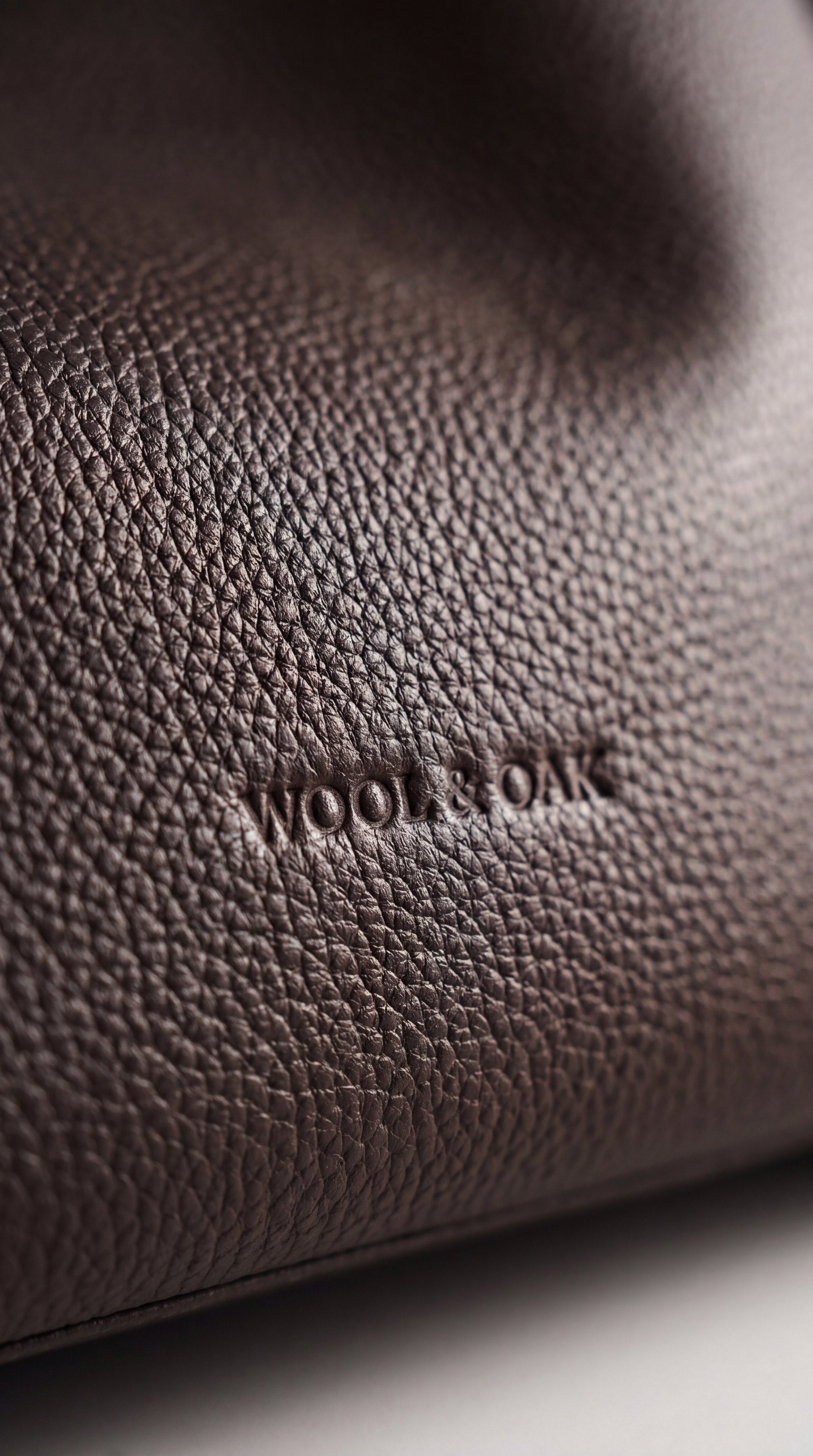 Full-grain pebbled leather with embossed Wool & Oak logo — Hobo detail