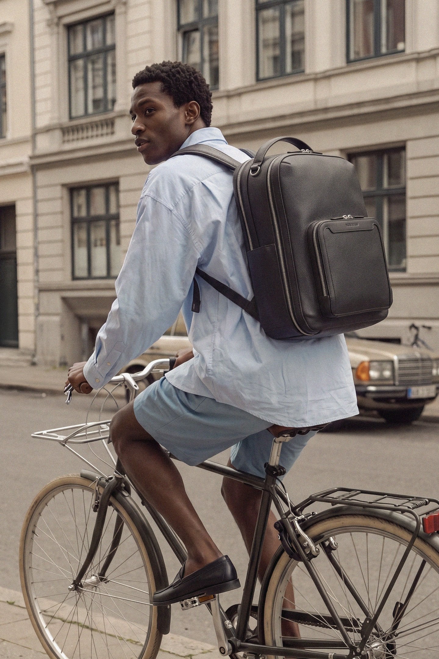 Man commuting by bike wearing the Pilot backpack in Jet Black